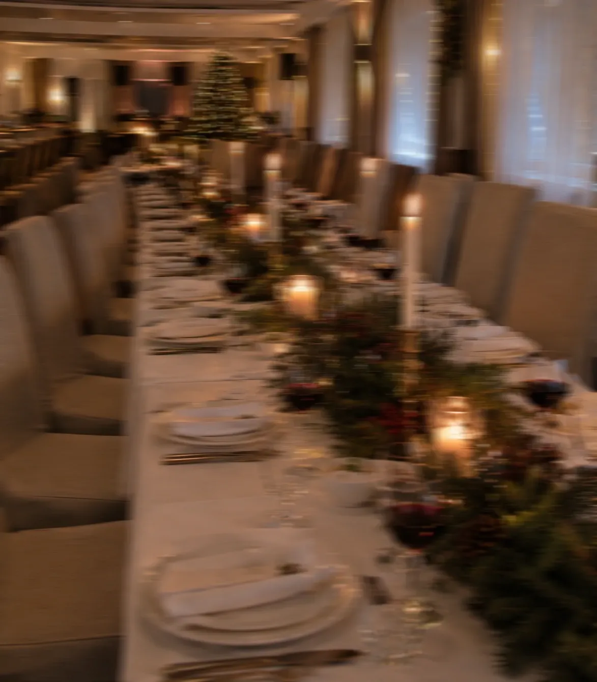 Świątecznie ubrany stół restauracyjny ze stroikami z gałązek i świecami